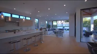 Still from the tour: open-plan kitchen with a stone island.