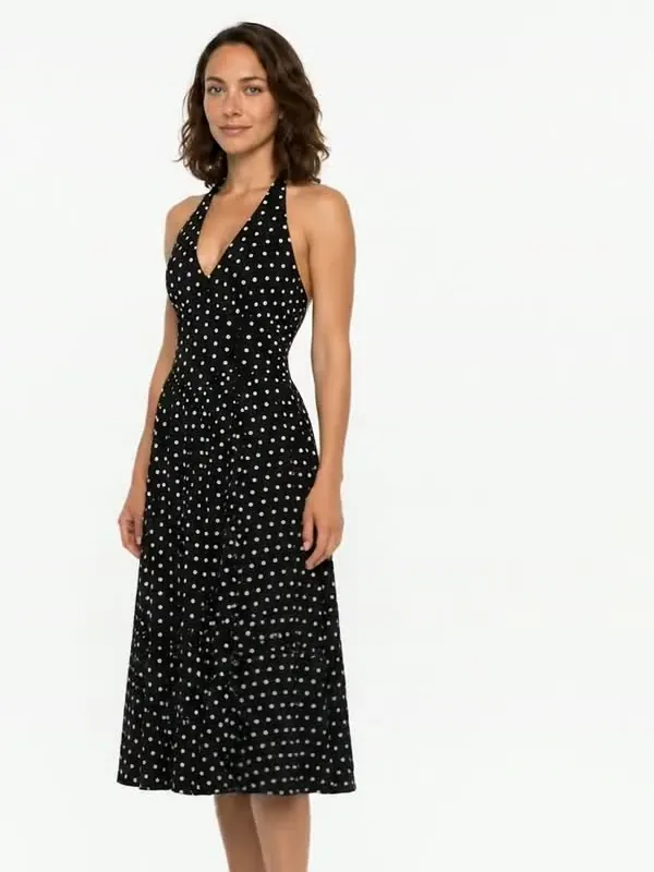 AI-generated model wearing a black polka-dot halter dress in a white studio.
